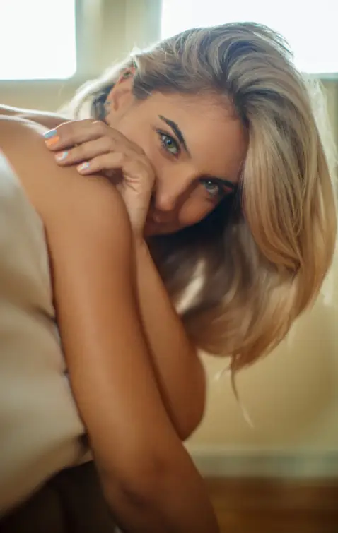 Blonde female at the edge of the bed